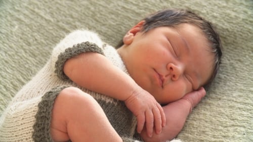 Sleeping Infant Wrapped in Knitted Blanket