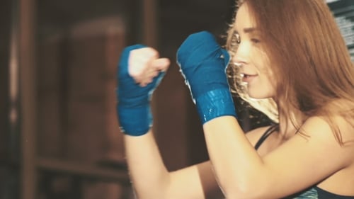 Pretty Kickboxing Girl Training With Punching Bag In a Fitness Gym