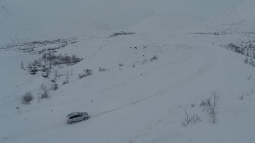 Car On Heavy Snowy Road In Mountains, Aerial View