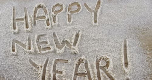 A palavra feliz ano novo escrita em farinha polvilhada 4k