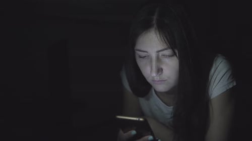 Woman Using Smartphone in the Dark at Night