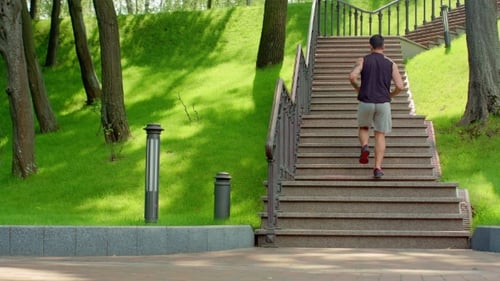 Man Running Up Stairs in Sunny Urban Park