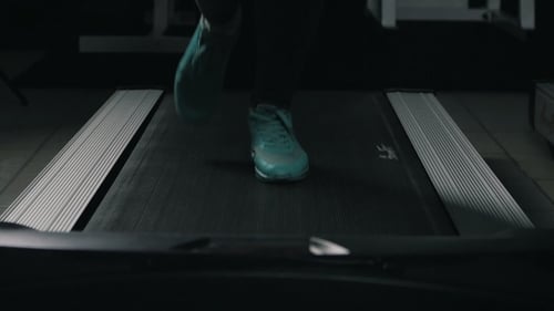 Pies de mujer corriendo en una cinta de correr en el gimnasio deportivo