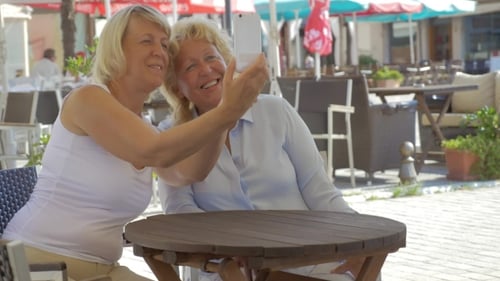 Senior Women Friends Taking Selfie In Street Cafe