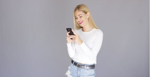 Smiling Woman Using Smartphone in Studio Setting