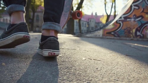 Feet Walk with Skateboard on Asphalt Path