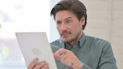Man Using Tablet Device in Bright Indoor Setting