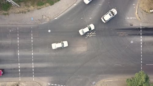 Top down aerial view of city traffic with cars moving on a street at roads intersection.