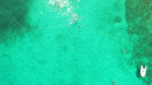 Aerial view of people swimming in turquoise bay