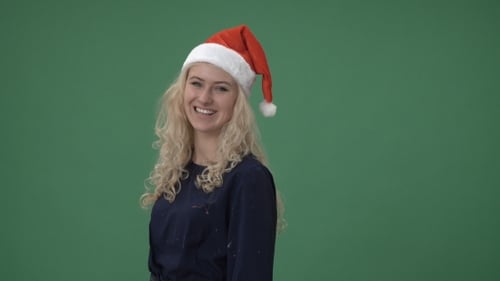 Smiling Woman Wearing Santa Hat, Green Background