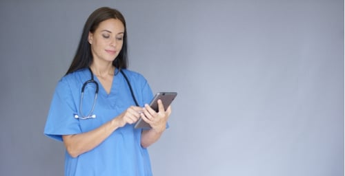 Young Female Doctor In Scrubs Using a Tablet