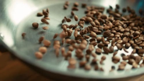 Coffee Beans Falling Into Silver Bowl