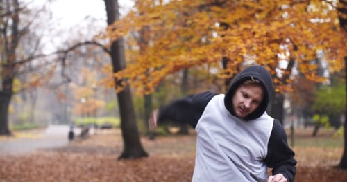 Man Exercises in an Autumn Park Setting