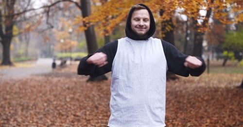 Man Stretching Arms in Autumn Park