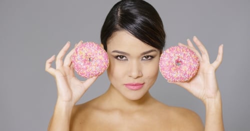 Woman Poses with Pink Donuts in Studio