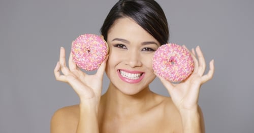 Glamorous Woman Posing with Pink Frosted Donuts