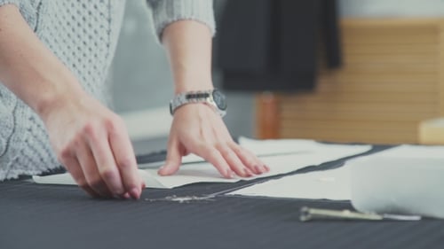 Hands Working with Fabric Pattern for Sewing