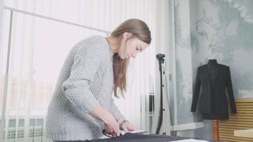 Woman Cutting Fabric in a Fashion Studio