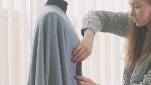 Woman Fitting Fabric on Dress Form Mannequin