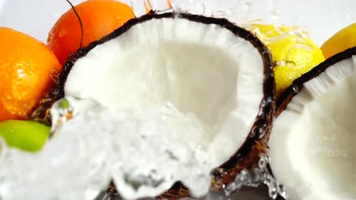Water Splashing on Halved Coconut and Citrus Fruits
