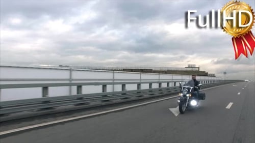 Biker Rides on Classic Motocyle on the Highway
