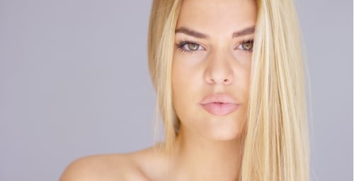 Beautiful Blond Woman Posing in Front of Grey Background