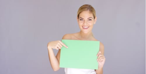Attractive Blond Woman Holding a Blank Green Sign
