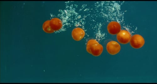 Orange Cherry Tomatoes Falling Into Water