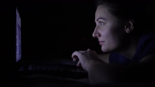 Woman Works on Laptop Computer at Night