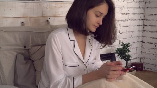Woman Uses Smartphone in Bed