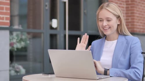 Young Woman on Laptop During Video Call Outdoors