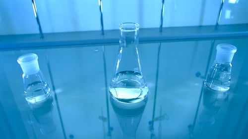 Laboratory Beakers with Fluid on Reflective Surface