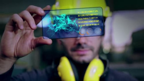 Un ouvrier d'usine utilise un futur dispositif d'écran holographique pour contrôler la fabrication