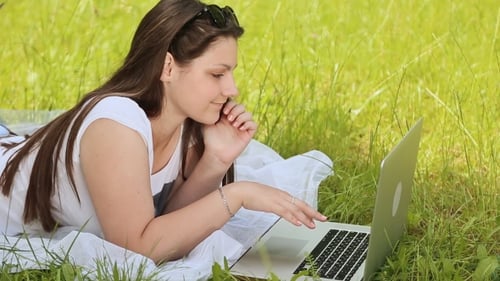 Mädchen mit Laptop im Freien auf dem Rasen