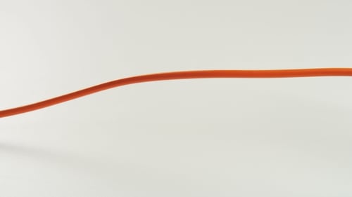 Orange Electrical Cord Plugged into Surge Protector