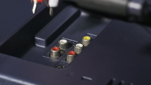 Hand Connecting Audio Video Cables Into TV Ports