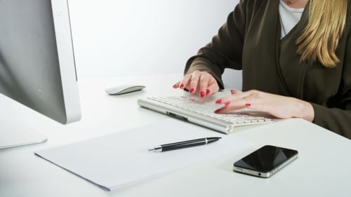 Woman Typing on Keyboard at Office Desk