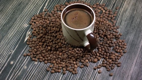 Cup of Coffee with Coffee Beans on Wood
