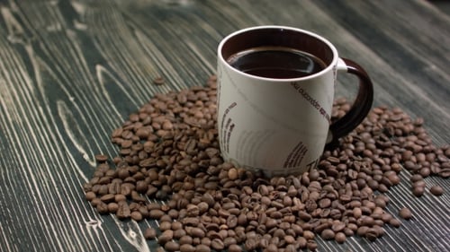 Coffee mug surrounded by fresh coffee beans