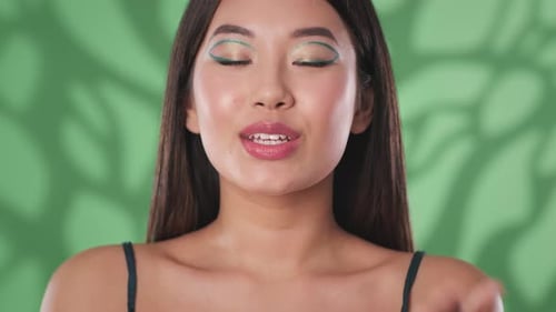 Smiling Woman Blowing a Kiss in Front of Green Screen