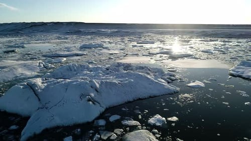 Flying Above Floating Icebergs. Ice From Glacier Crystal Shining on Sunset. Ice Lagoon