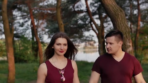Beautiful Brunette Couple Walk in Nature, Smile, Enjoy Time Together. They Look Happy and Glad