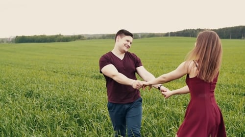 Attractive Couple Enjoying Their Time Together, Walking Through a Wheat Field, Holding Hands