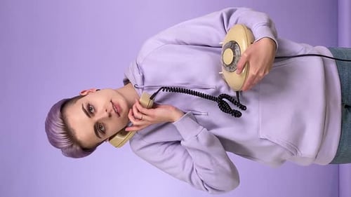 Prise de vue verticale jeune personne parlant à l'aide d'un téléphone filaire rétro à l'intérieur