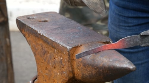 Blacksmith Shaping Red Hot Metal on Anvil