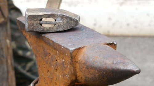 Blacksmith Shaping Metal on Anvil with Hammer