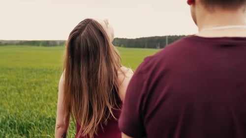 A Young Woman Is Happy with Her Lover, Walking in a Green Field, Taking Him By the Hand. , Steadicam