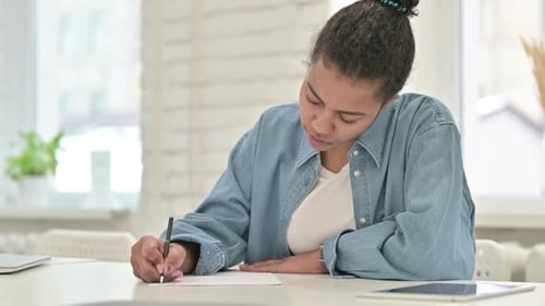 Young Adult Woman Writing on Paper Indoors