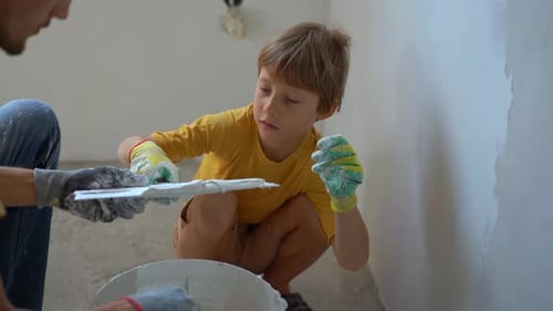 Child Helping Adult Plastering at Home