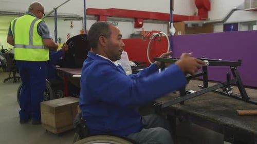 Men Assembling Metal Frames in Factory Workplace